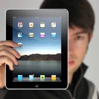 a man holding an ipad infont of himself